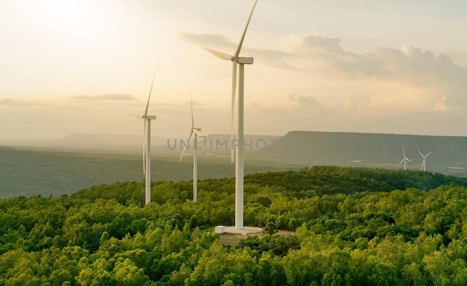 Wind energy. Wind power. Sustainable, renewable energy. Wind turbines generate electricity. Windmill farm on mountain with sunset sky. Green technology. Renewable resource. Sustainable development.