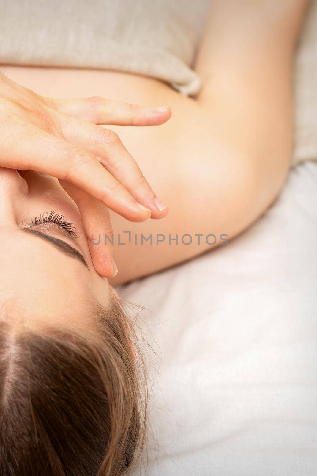 Face massage with fingers of a masseur. Female facial skin care at a beauty spa salon