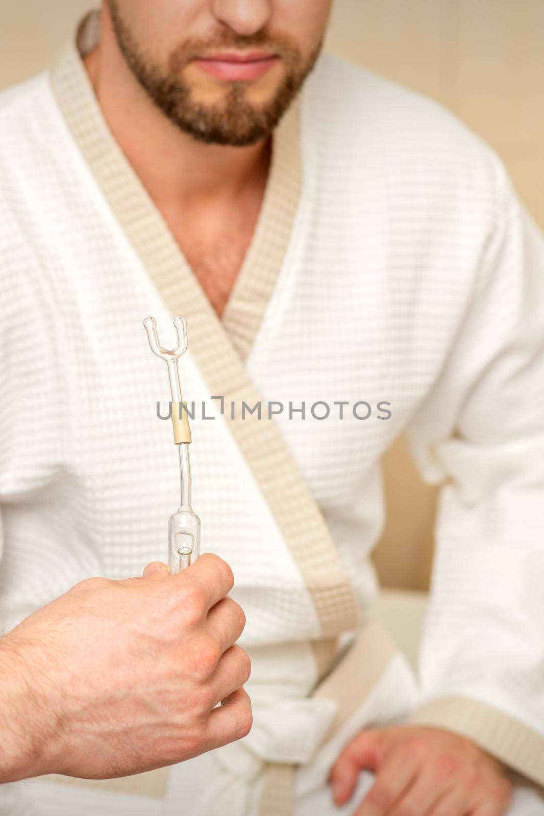 Doctor giving nasal inhalator with essential oil Maholda to a male patient in spa