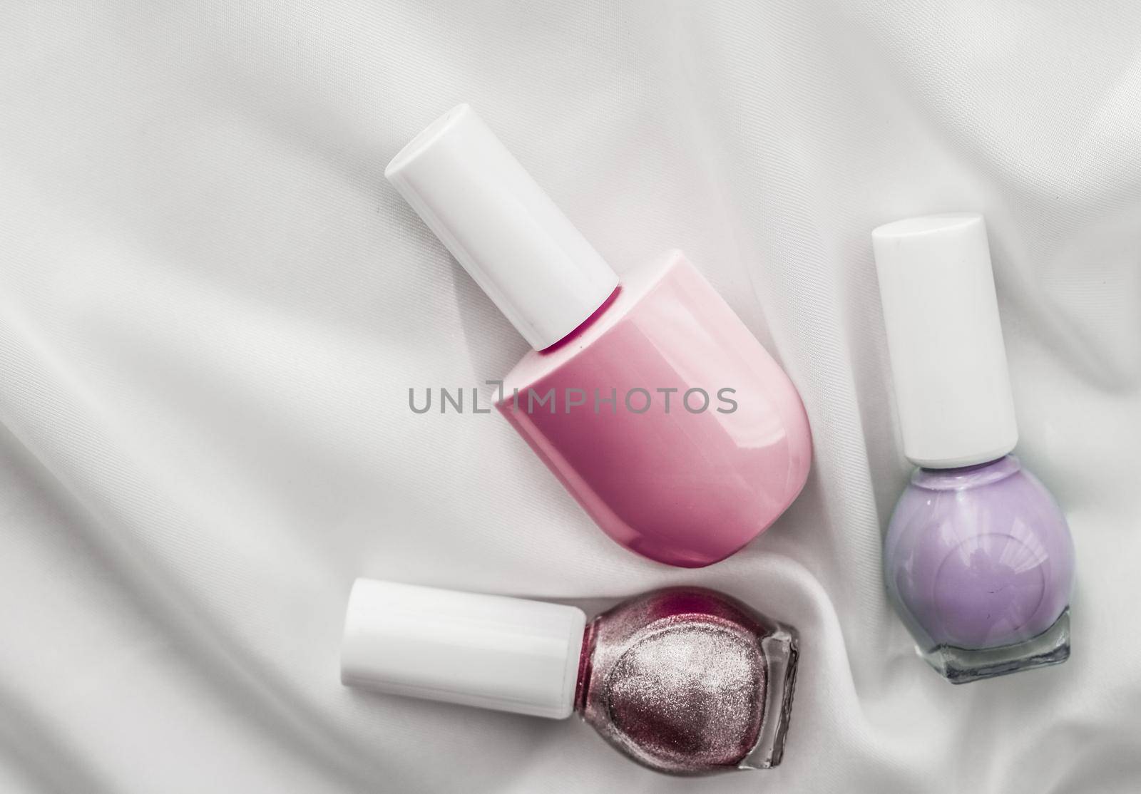 Cosmetic branding, salon and glamour concept - Nail polish bottles on silk background, french manicure products and nailpolish make-up cosmetics for luxury beauty brand and holiday flatlay art design