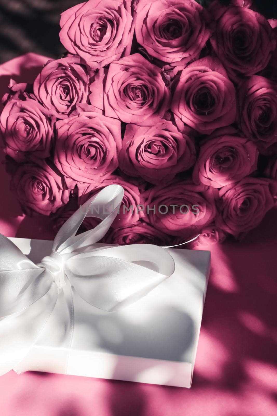 Luxury holiday silk gift box and bouquet of roses on pink background, romantic surprise and flowers as birthday or Valentines Day present by Anneleven