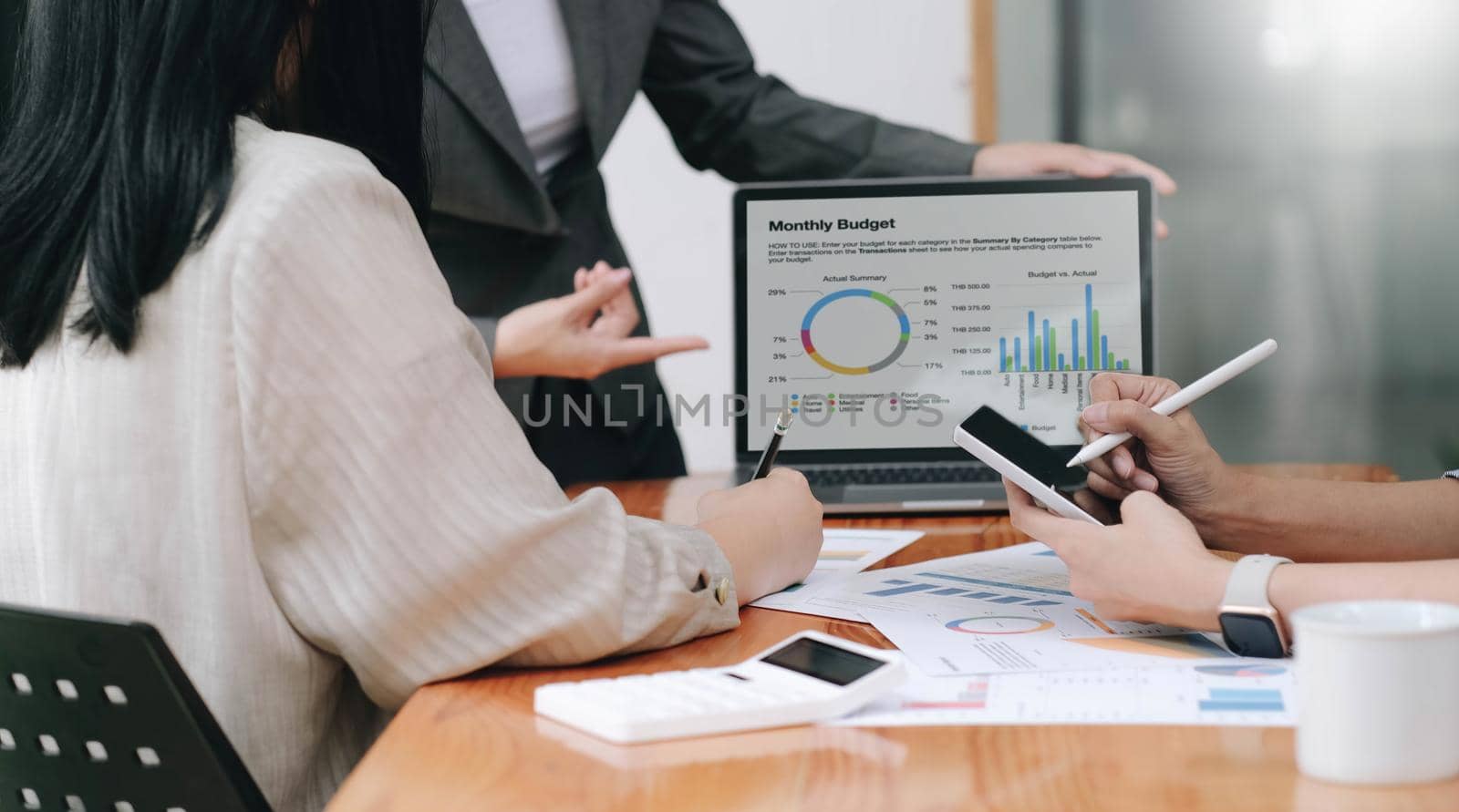 Business asian presenting analytical report while working together with colleagues in the modern office.