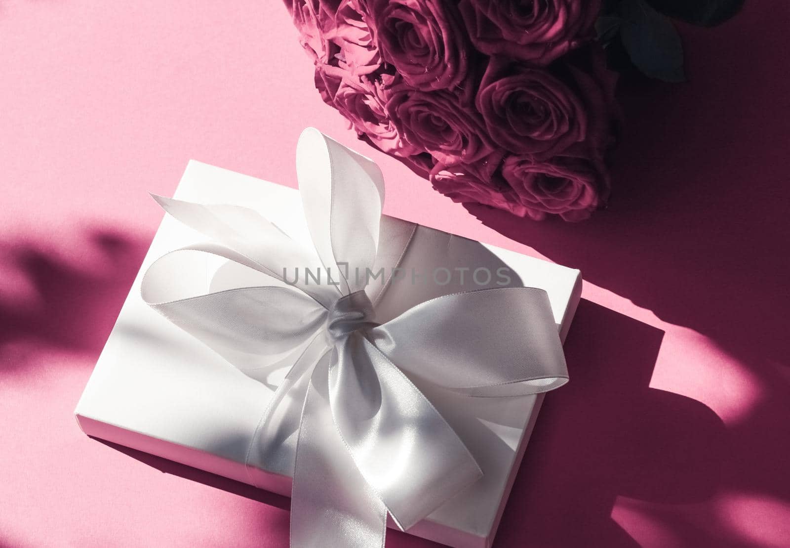 Happy holidays, luxe shopping and love gifts concept - Luxury holiday silk gift box and bouquet of roses on pink background, romantic surprise and flowers as birthday or Valentines Day present