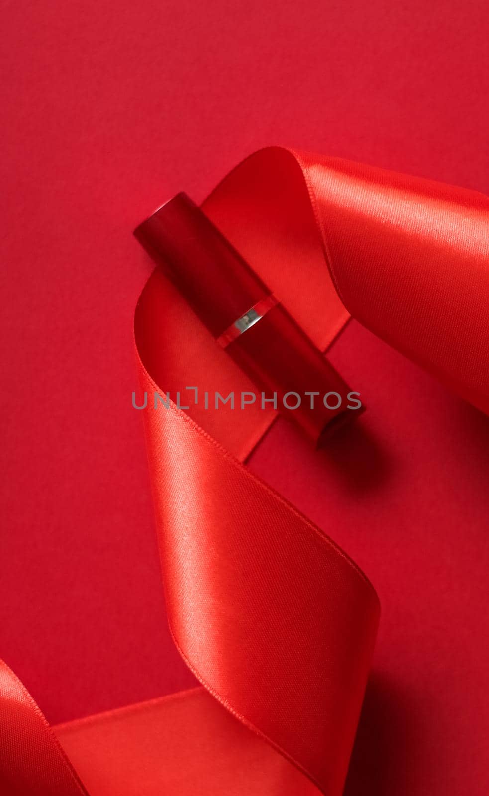 Luxury lipstick and silk ribbon on red holiday background, make-up and cosmetics flatlay for beauty brand product design by Anneleven