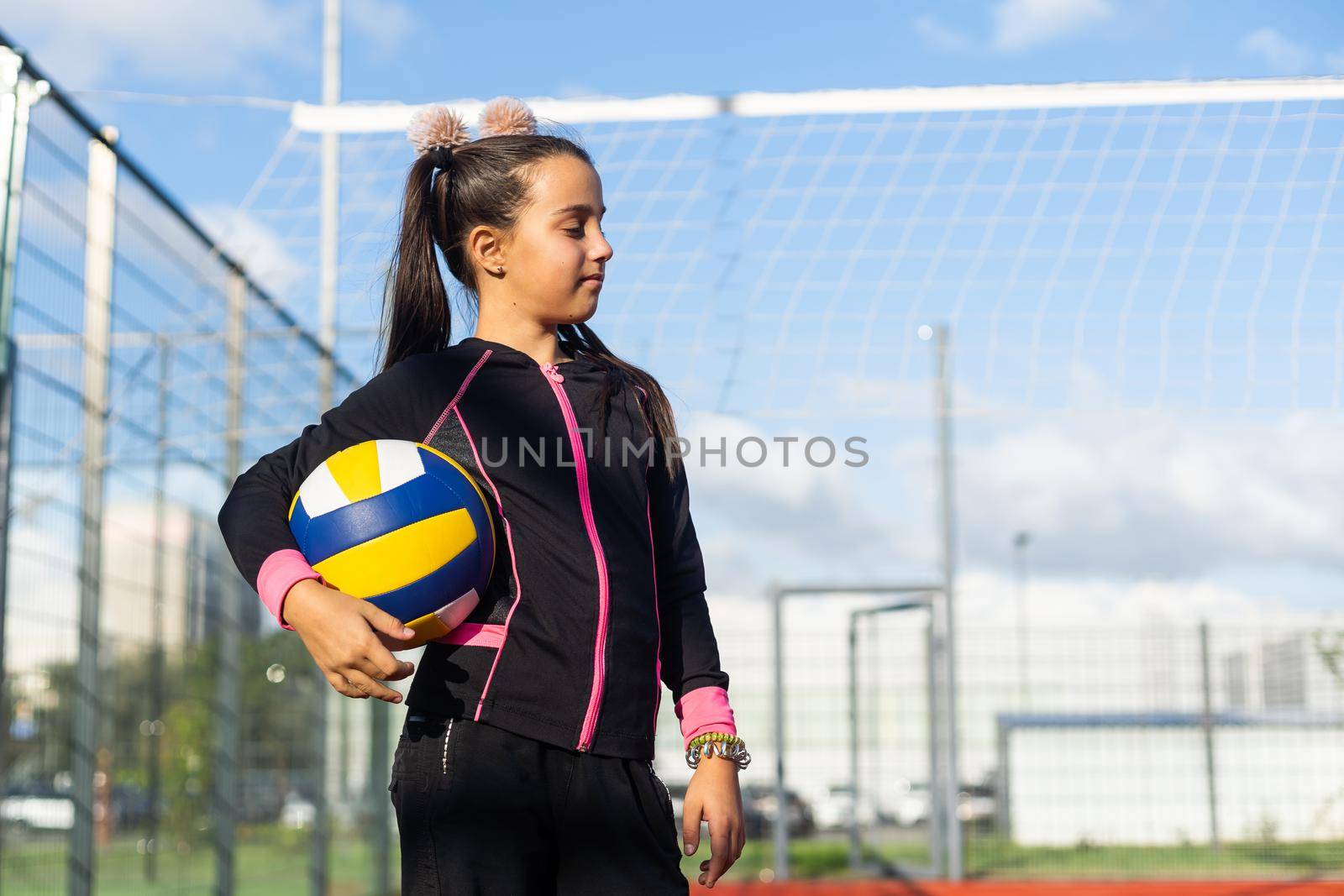 Cute girl playing ball. Girl with a blue-yellow volleyball.