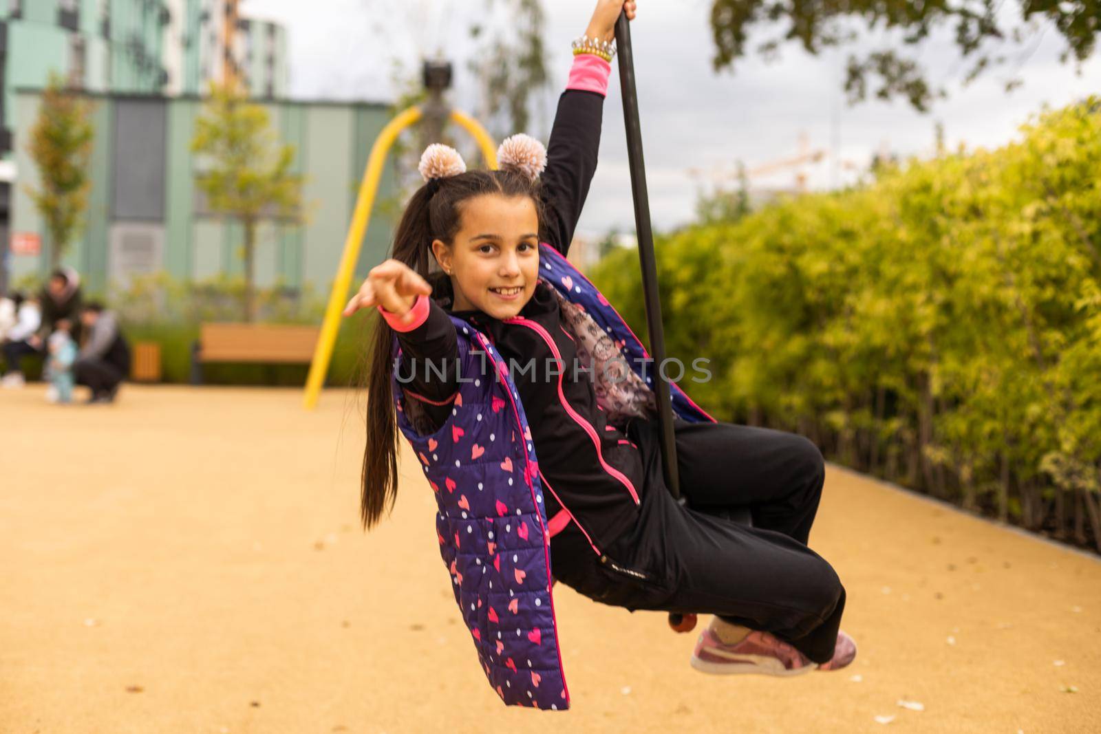 Little girl rides on Flying Fox play equipment. Child girl is smiling in a children's playground