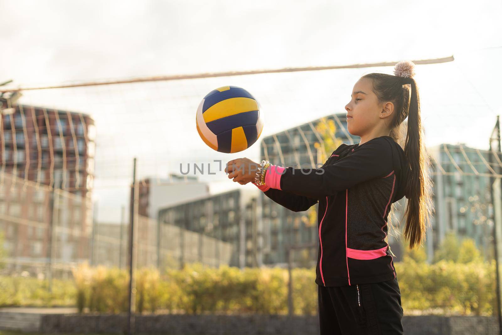 Cute girl playing ball. Girl with a blue-yellow volleyball by Andelov13