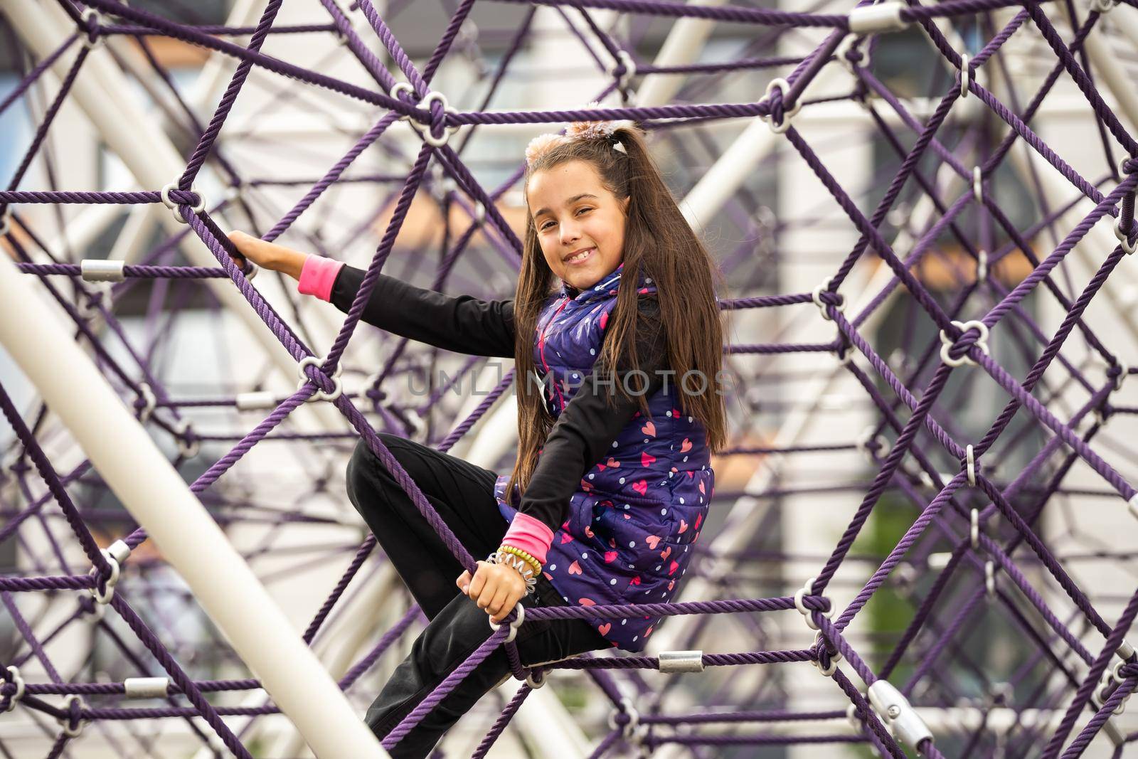 Portrait of a little girl at the playground. Girl playing in a maze by Andelov13