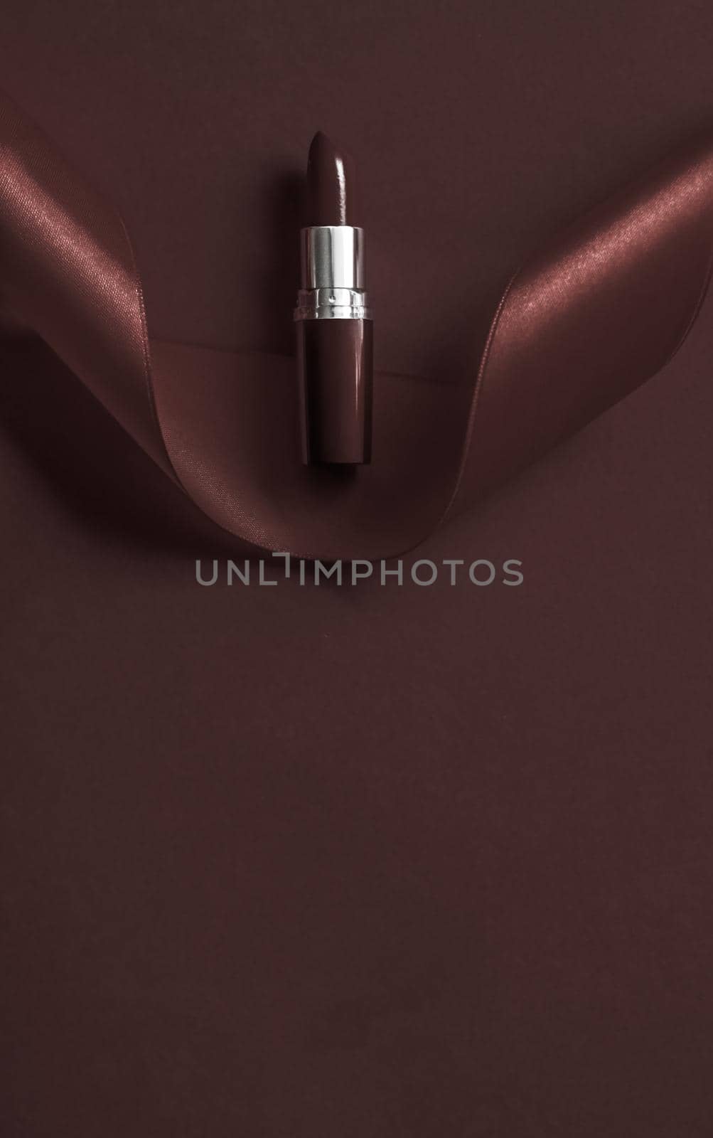 Cosmetic branding, glamour lip gloss and shopping sale concept - Luxury lipstick and silk ribbon on chocolate holiday background, make-up and cosmetics flatlay for beauty brand product design