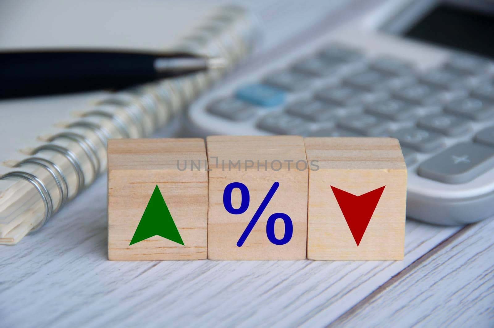 Wooden blocks with icon percentage and symbol arrow up and down. Business and Interest fluctuation concept.