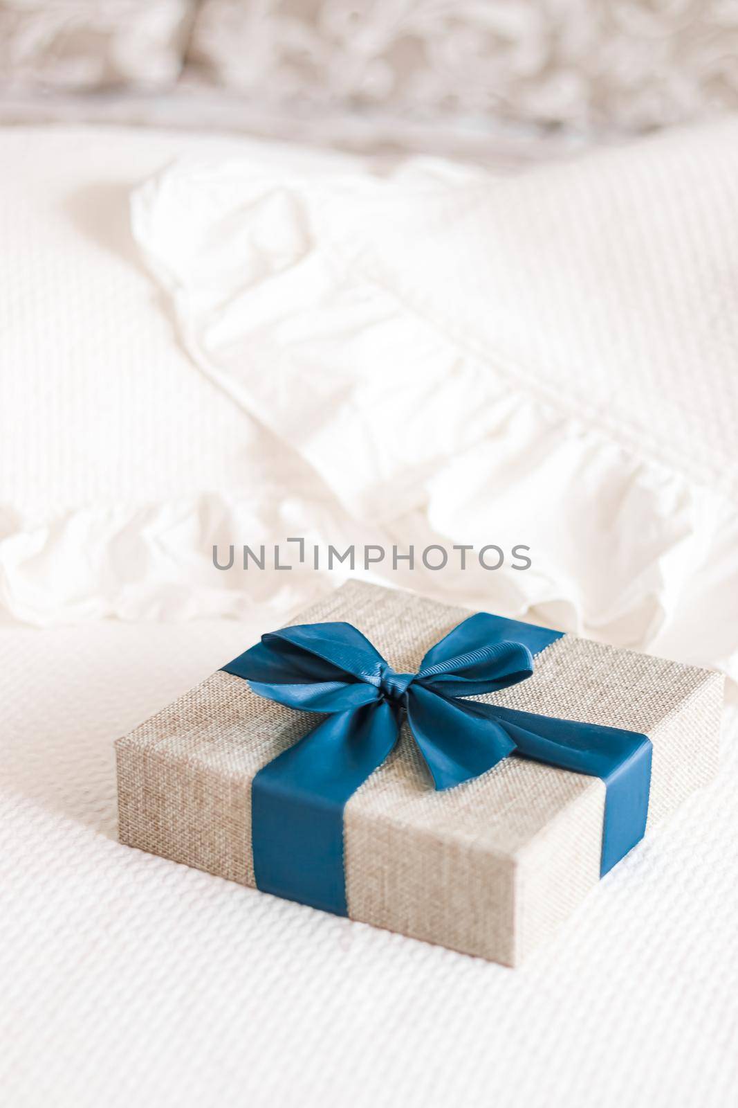 Holiday present and luxury online shopping delivery, wrapped linen gift box with blue ribbon on bed in bedroom, chic countryside style by Anneleven