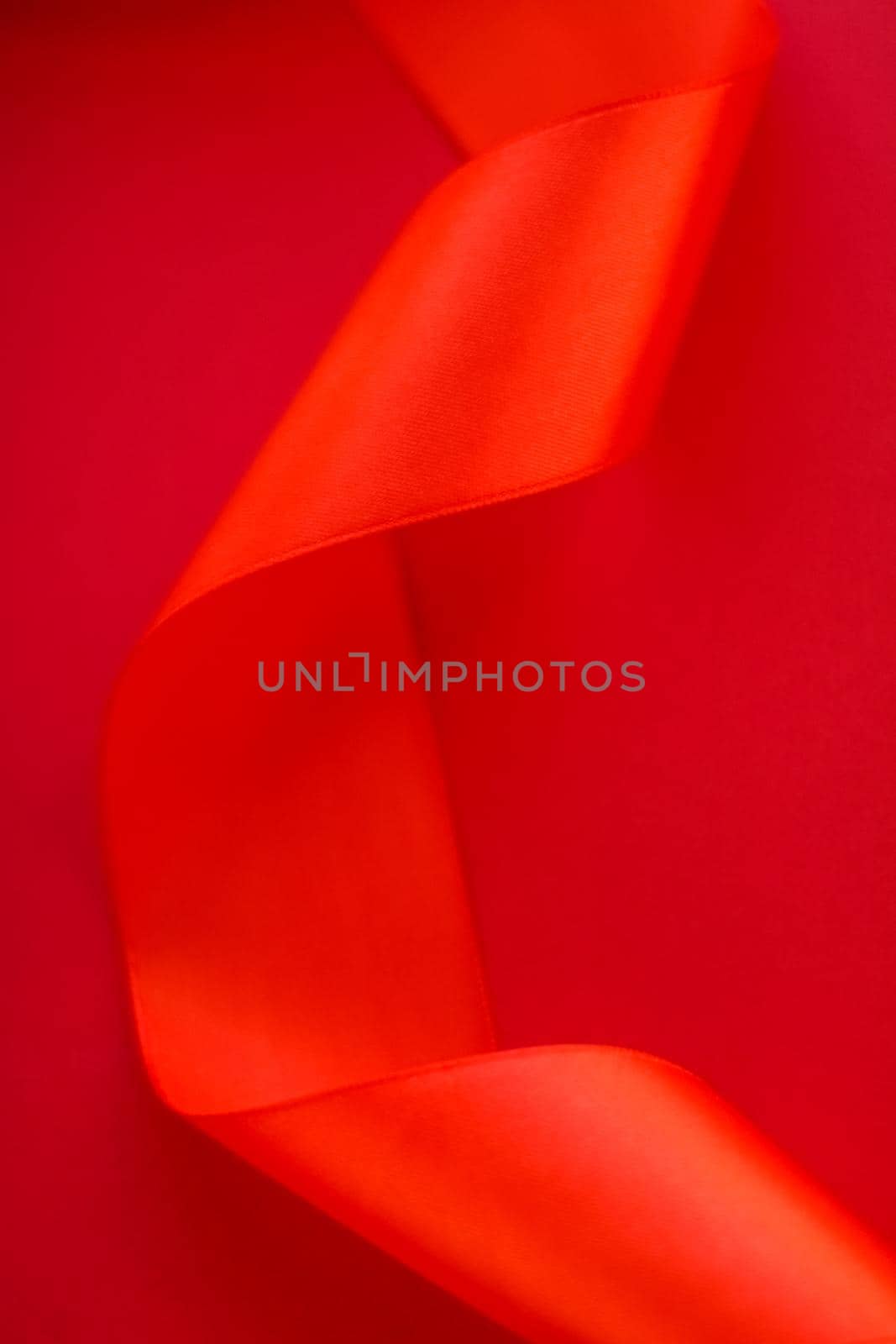 Branding, holidays and luxe brands concept - Abstract curly silk ribbon on red background, exclusive luxury brand design for holiday sale product promotion and glamour art invitation card backdrop