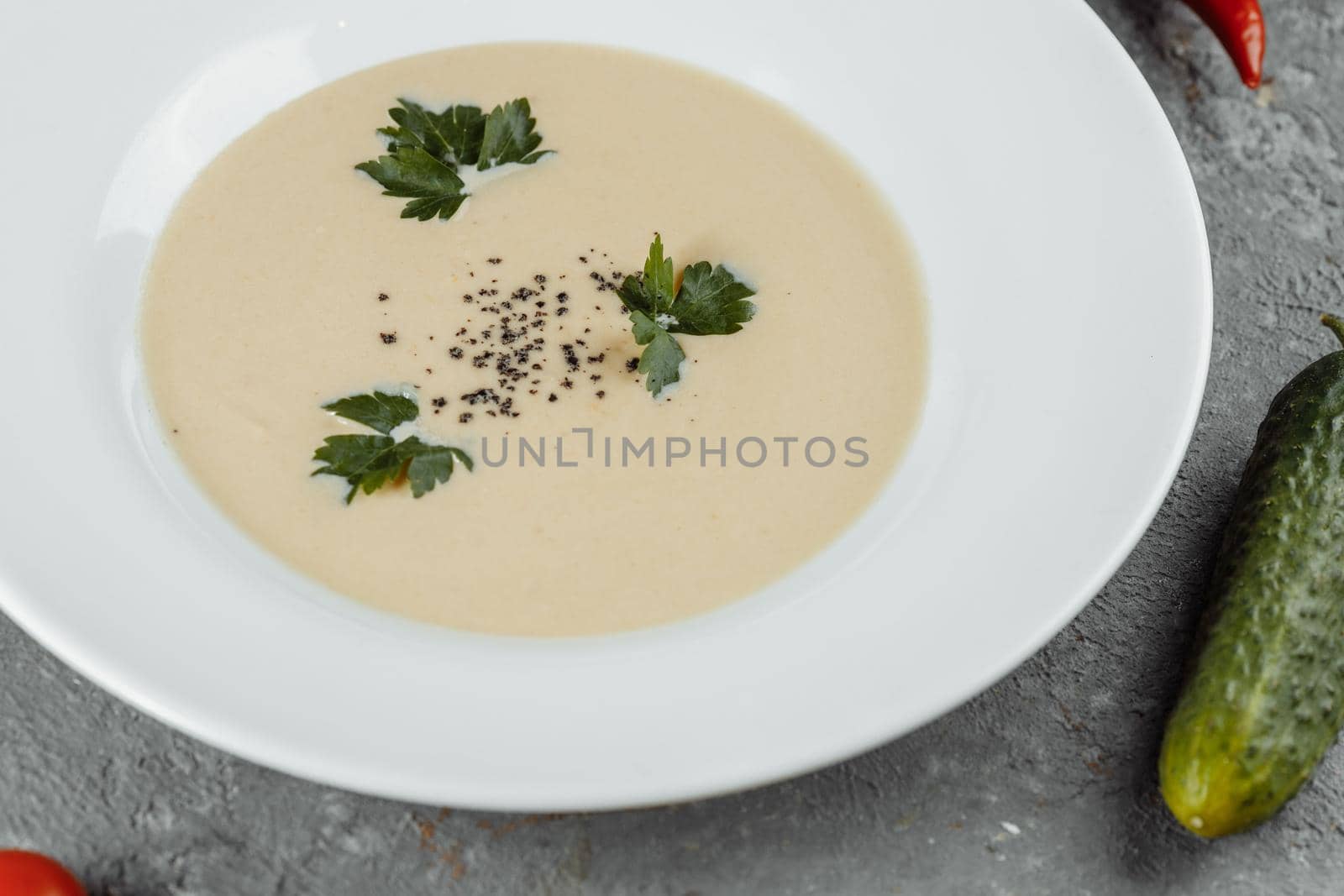 Cheese cream soup with sliced cheese and bread crumbs on a grey background by UcheaD