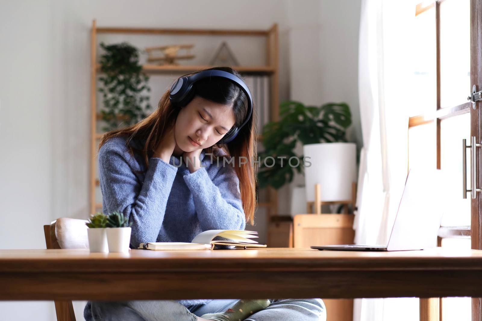 Beautiful Asian women get tired after studying online for a long time, she is studying online. The concept of online learning due to the COVID-19 outbreak to prevent an outbreak in the classroom. by wichayada