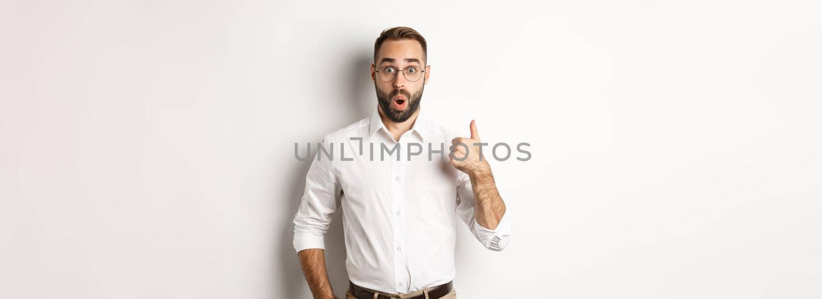 Impressed young male entrepreneur showing thumbs-up, praise something good, like and agree, white background by Benzoix