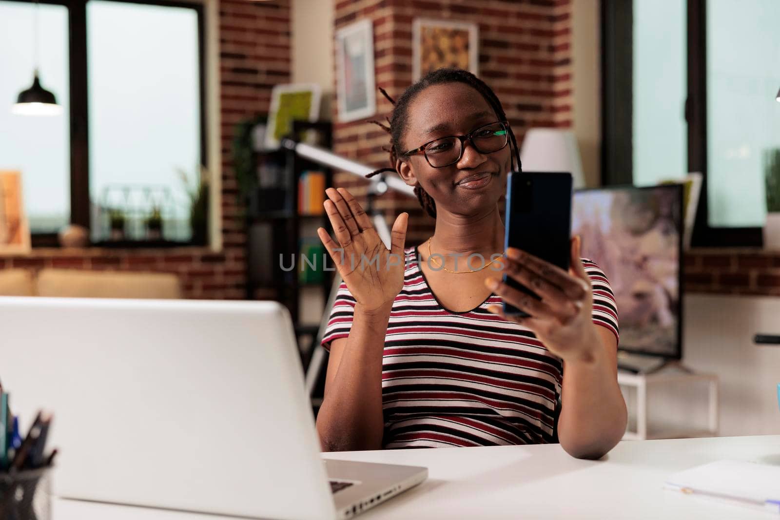 Smiling freelancer greeting client on videoconference interview by DCStudio