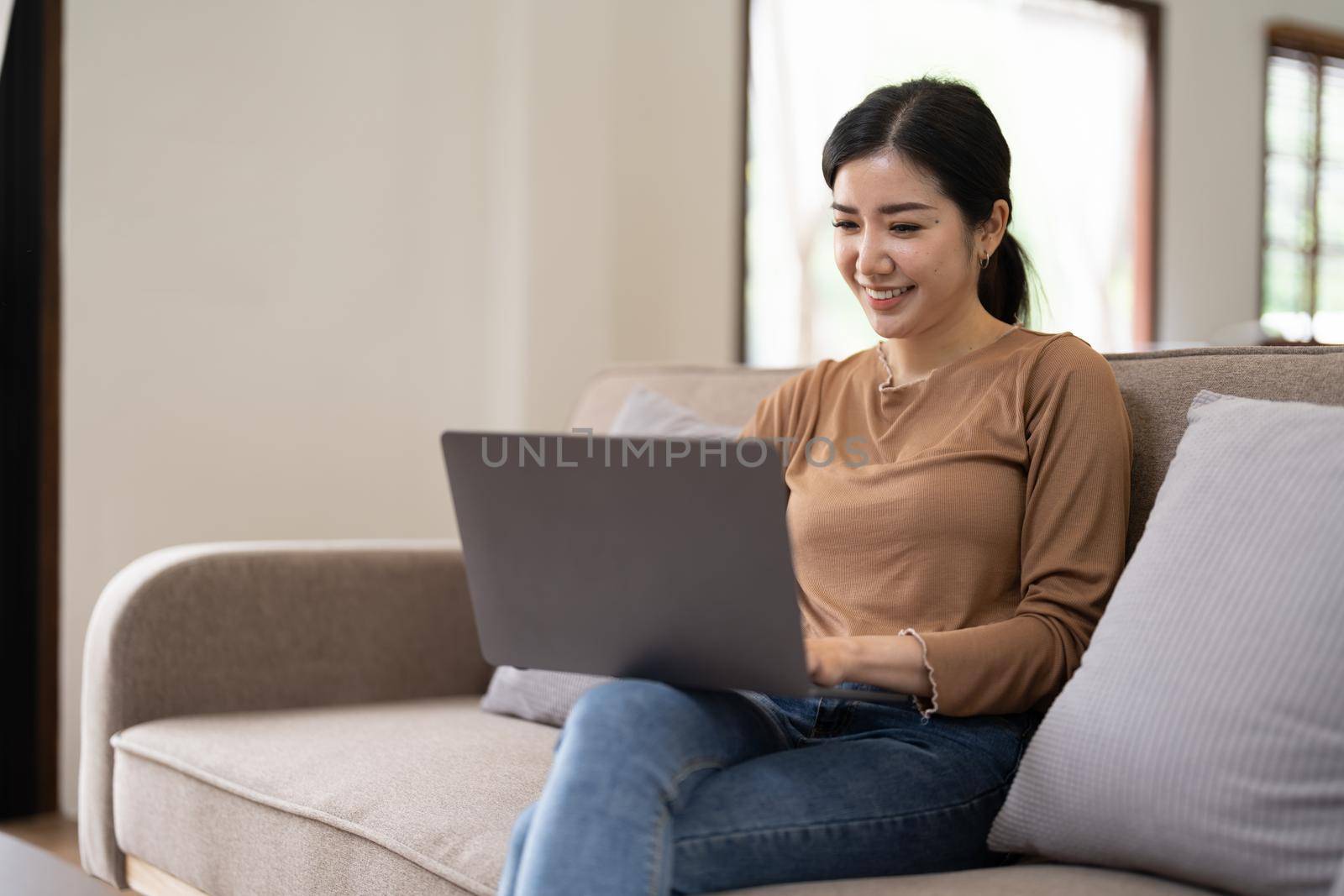 Young asian woman having conversation chatting while using laptop at house. Work at home, Video conference, Online meeting video call, Virtual meetings, Remote learning and E-learning by nateemee