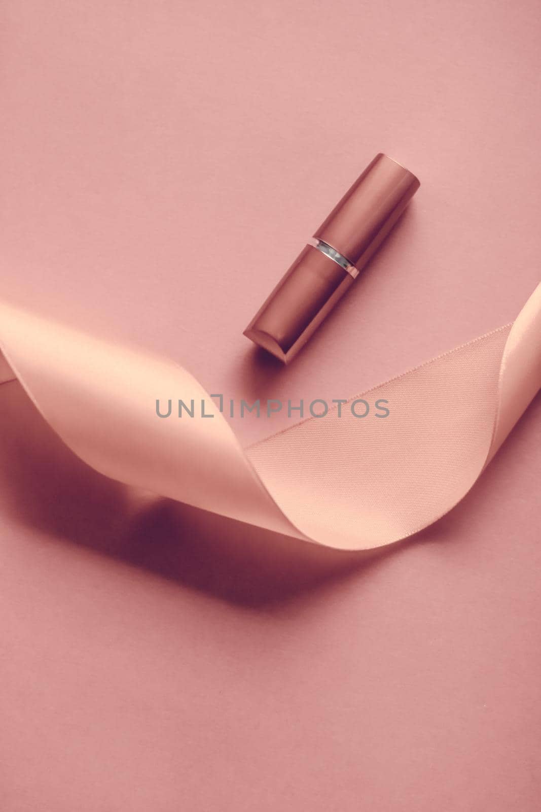 Luxury lipstick and silk ribbon on blush pink holiday background, make-up and cosmetics flatlay for beauty brand product design by Anneleven