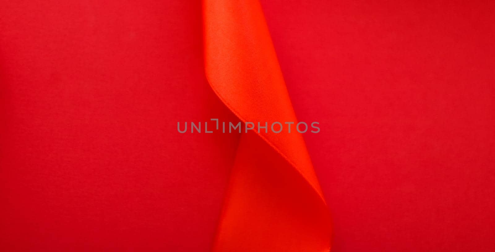 Branding, holidays and luxe brands concept - Abstract curly silk ribbon on red background, exclusive luxury brand design for holiday sale product promotion and glamour art invitation card backdrop
