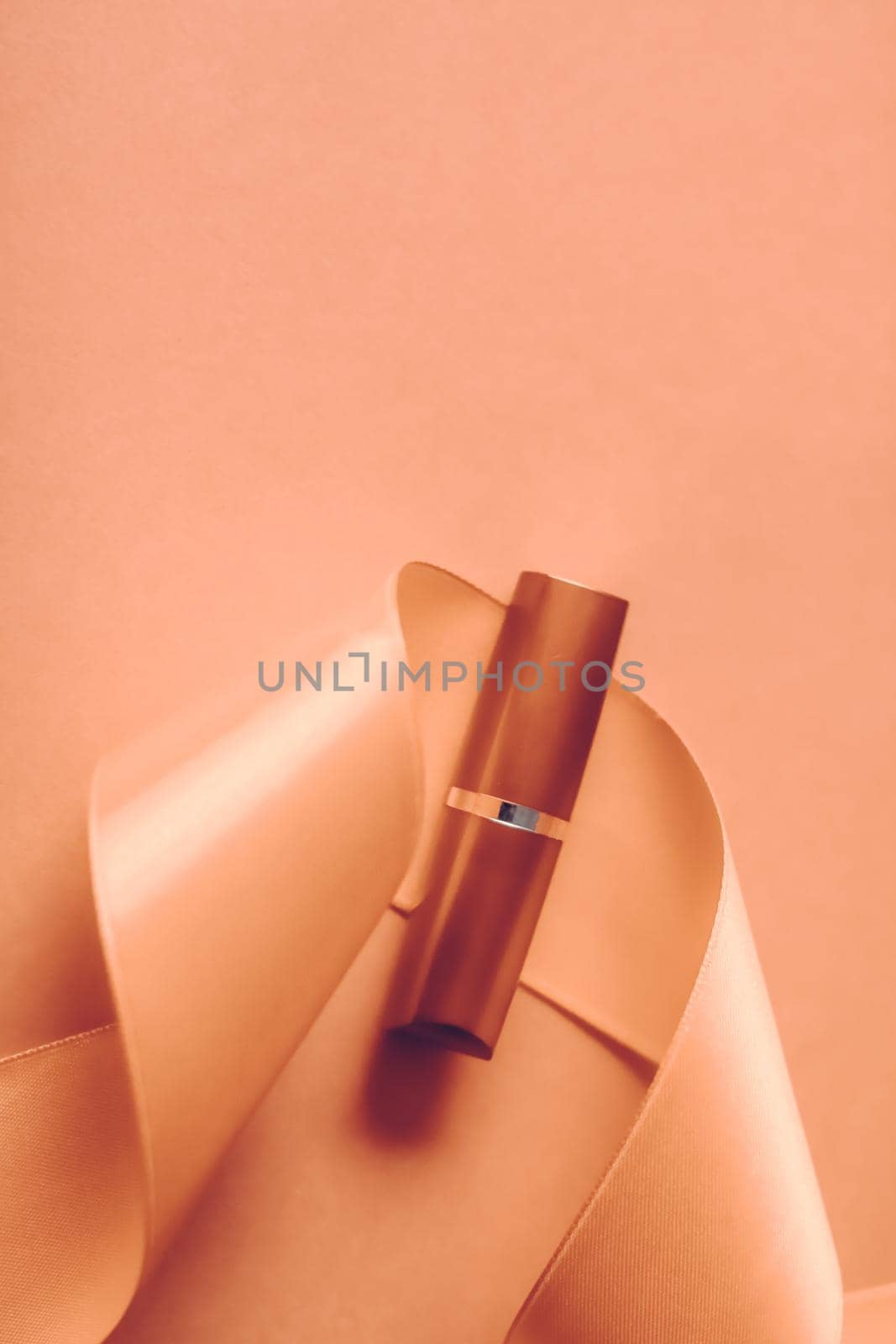 Cosmetic branding, glamour lip gloss and shopping sale concept - Luxury lipstick and silk ribbon on orange holiday background, make-up and cosmetics flatlay for beauty brand product design