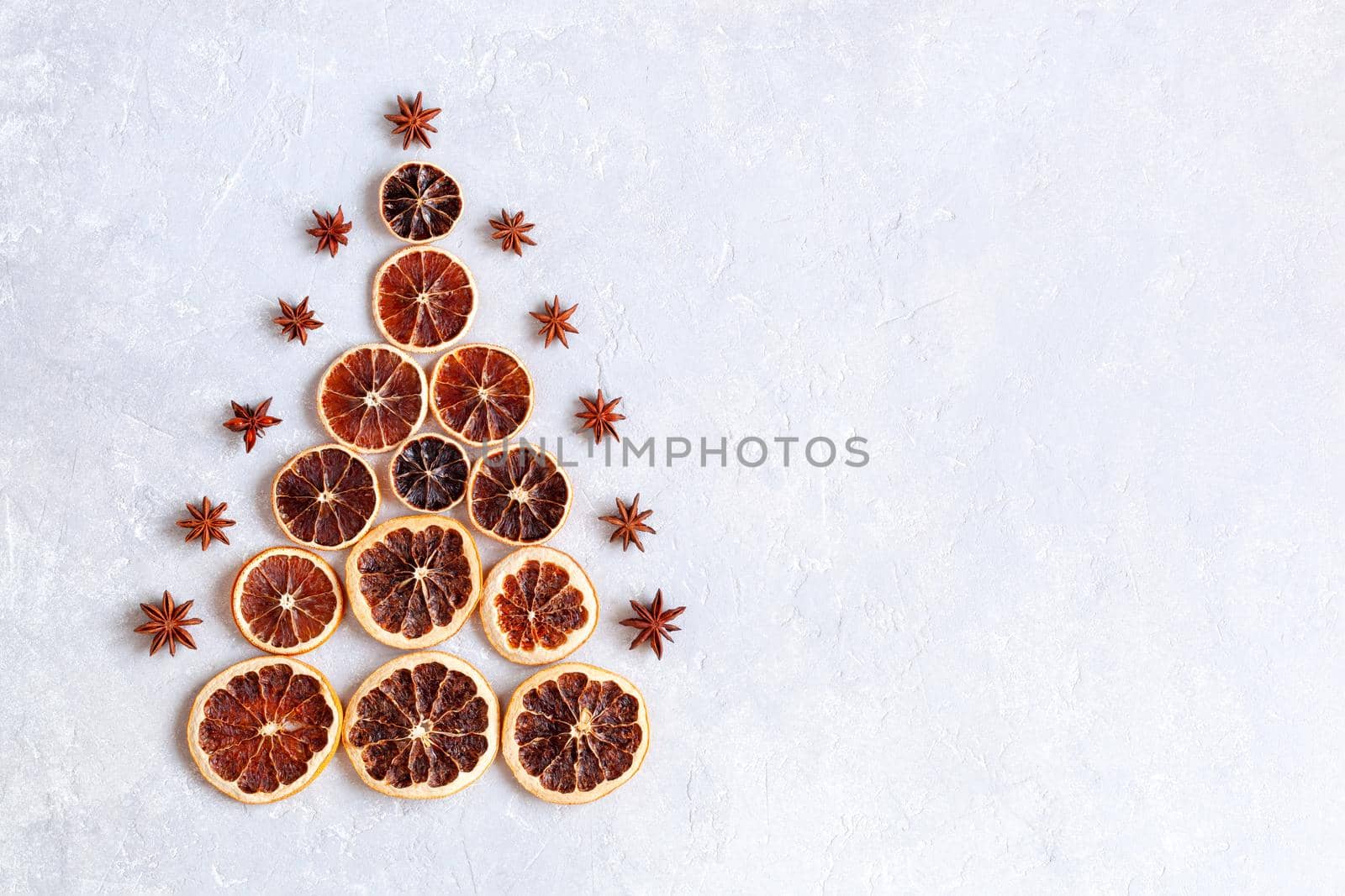 Christmas tree made of dry orange slices and decorated with anise stars, zero waste idea, top view, copyspace