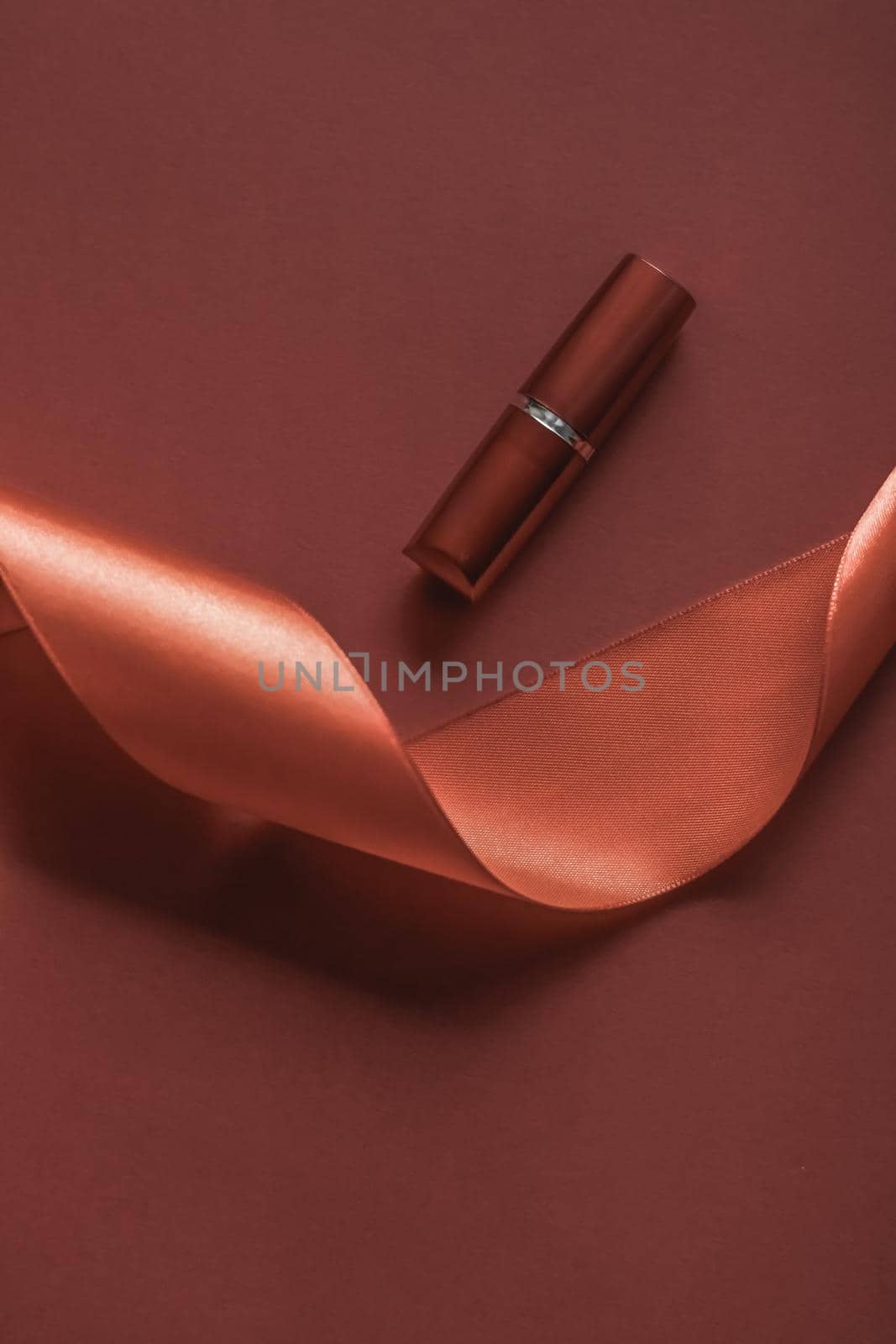 Cosmetic branding, glamour lip gloss and shopping sale concept - Luxury lipstick and silk ribbon on bronze holiday background, make-up and cosmetics flatlay for beauty brand product design