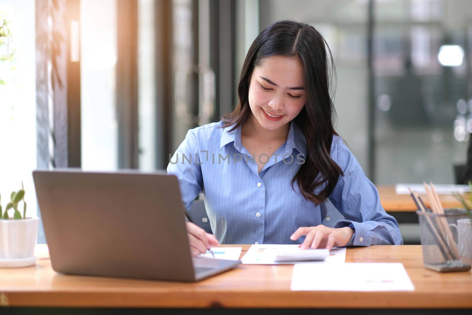 business woman hands using a calculator to check company finances and earnings and budget