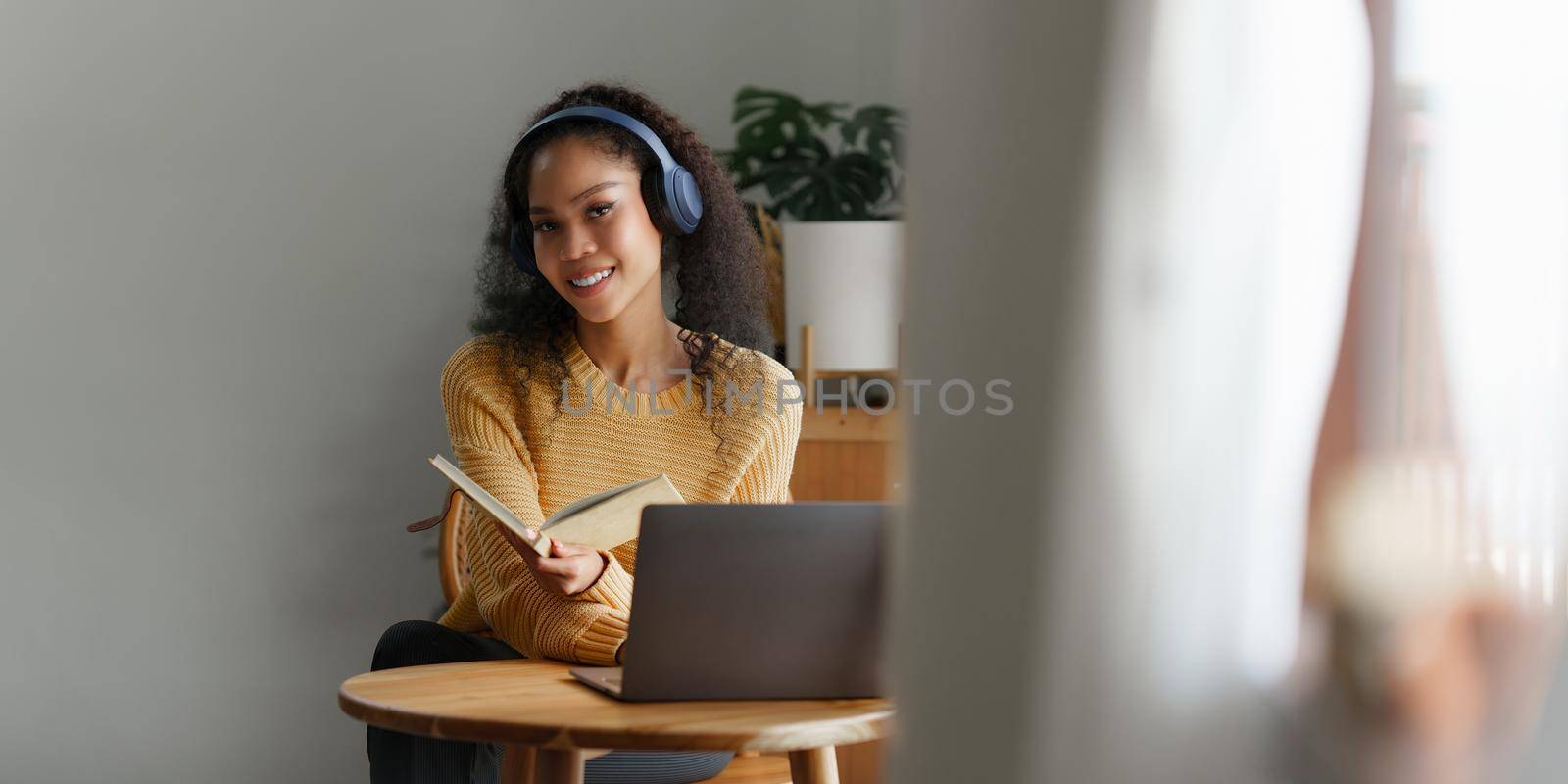 Beautiful woman using laptop and listening music with earphones.