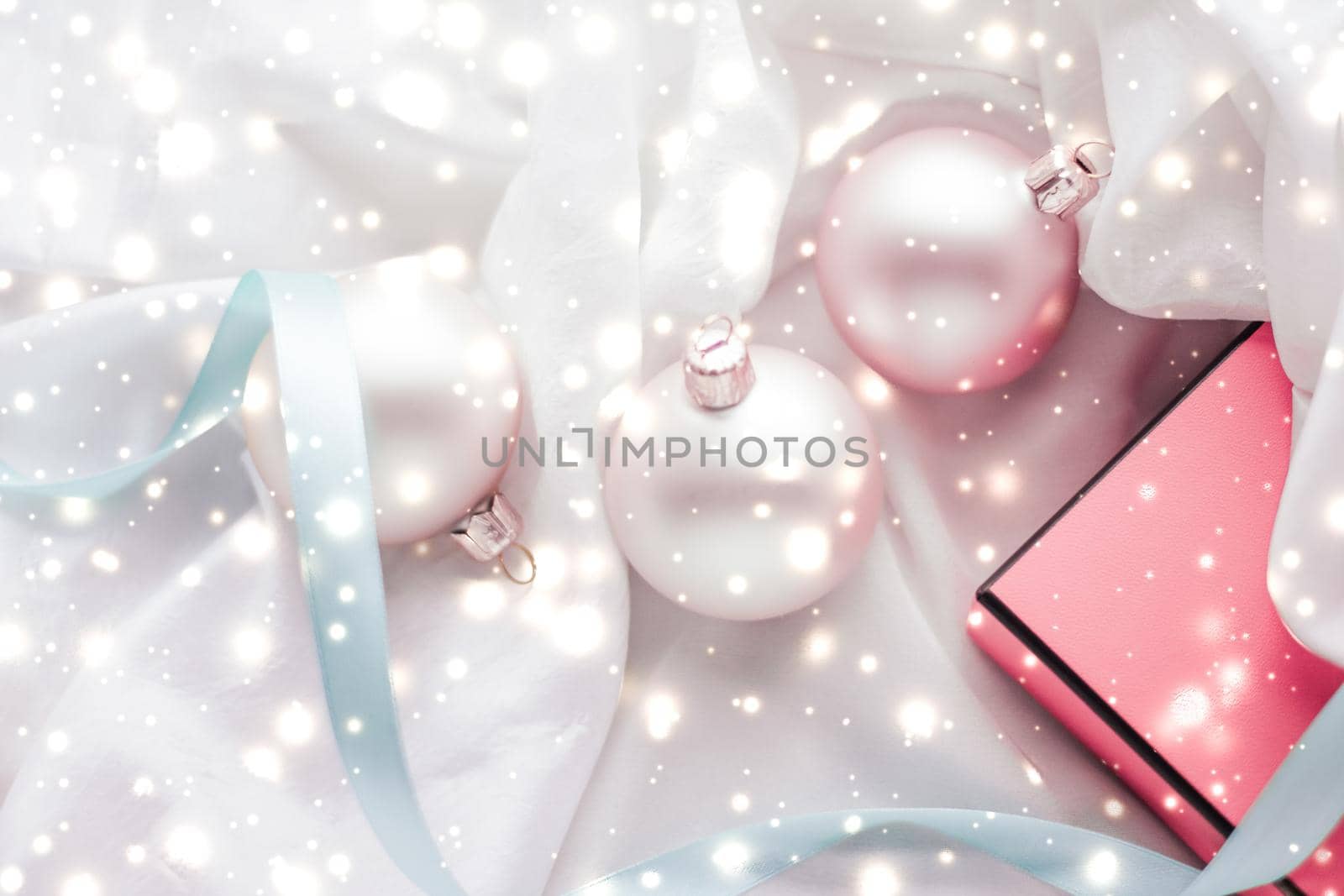Winter, celebration and new years eve concept - Christmas decoration and gift box with shiny snow on silk background, holiday season