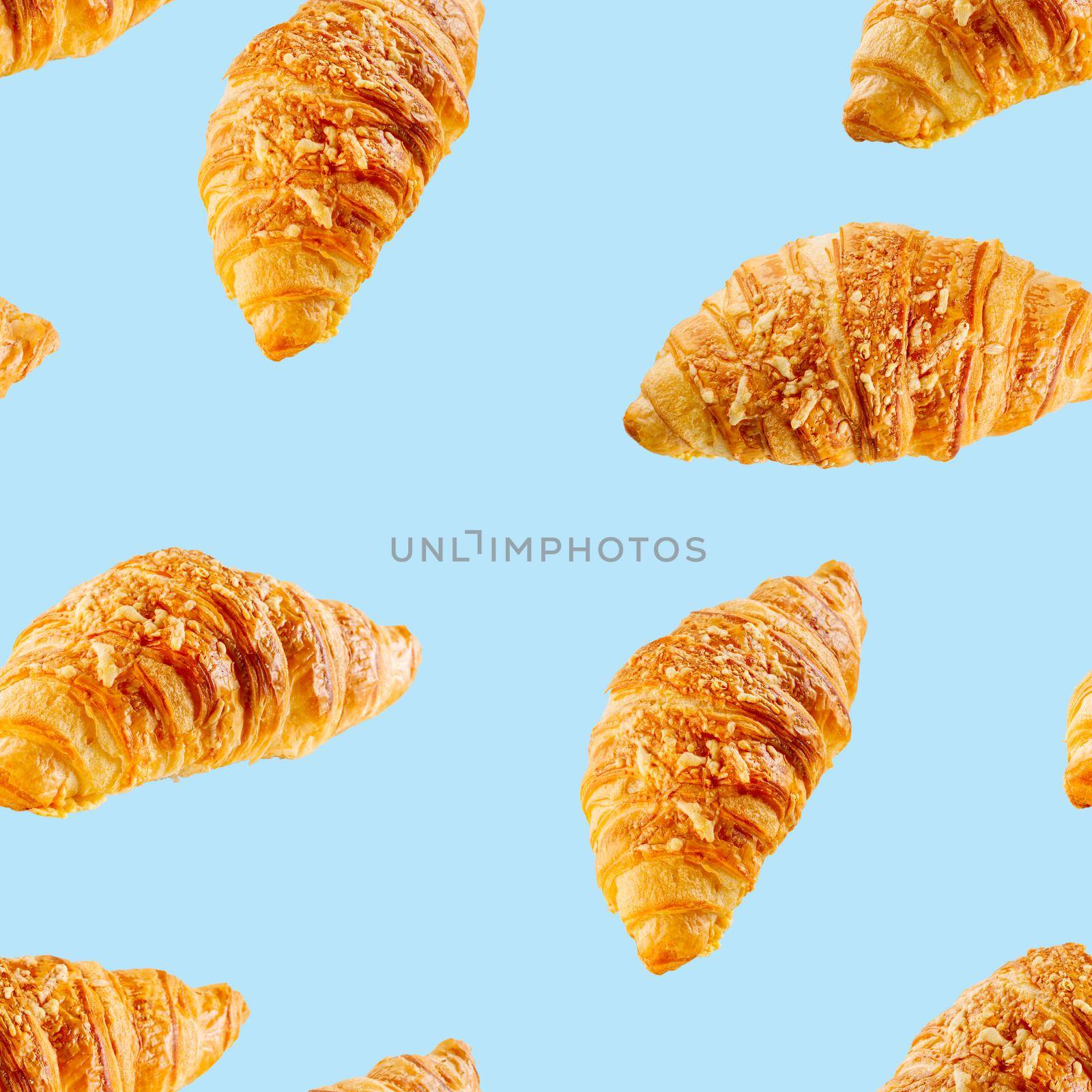 seamless pattern made from Fresh croissant with cheese isolated on blue background. by PhotoTime