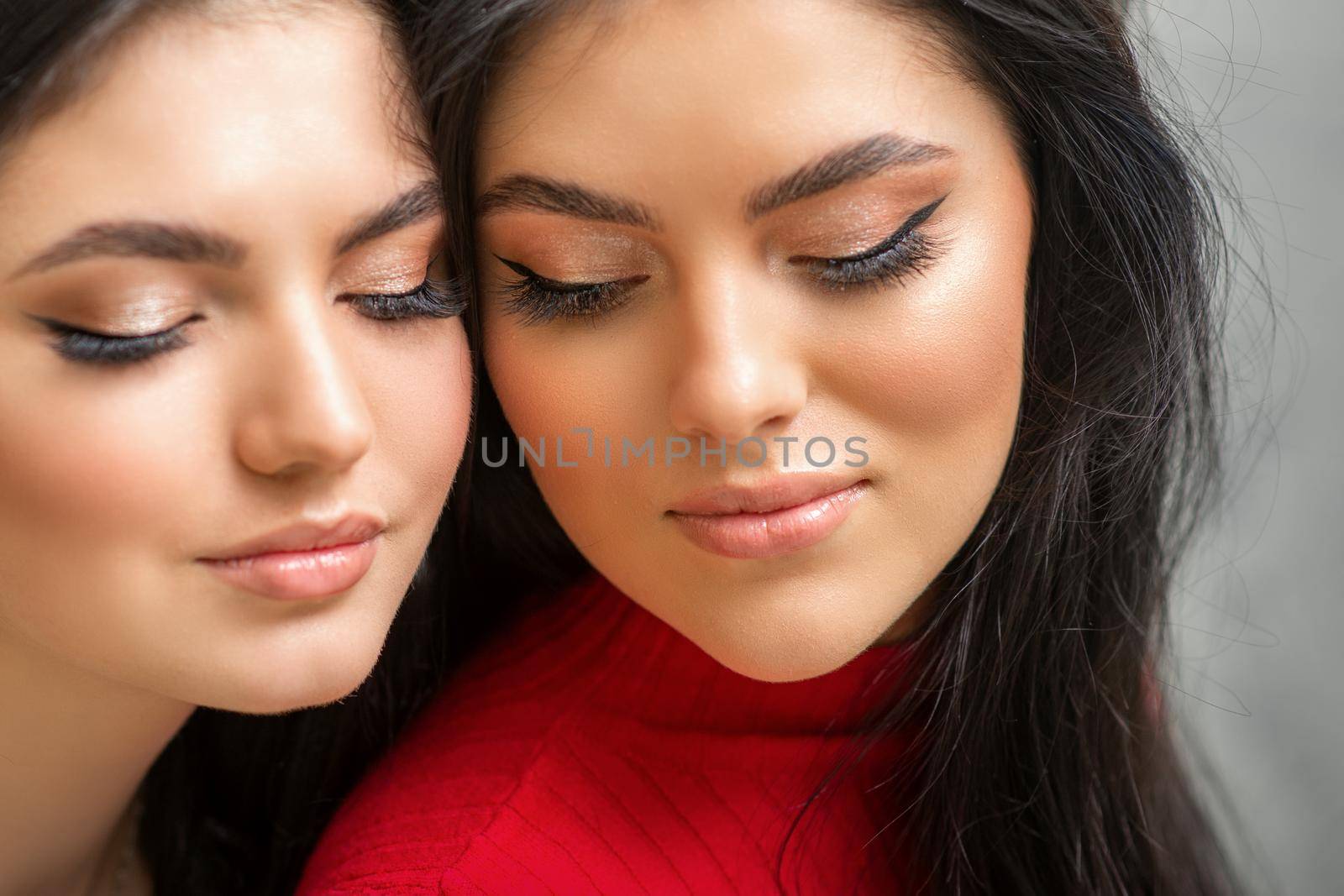 Portrait of young beautiful two women with long lashes and closed eyes after eyelash extensions