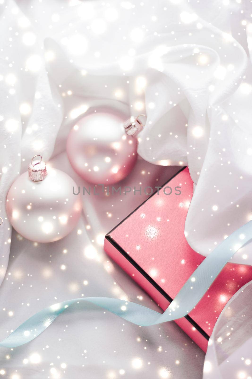 Winter, celebration and new years eve concept - Christmas decoration and gift box with shiny snow on silk background, holiday season