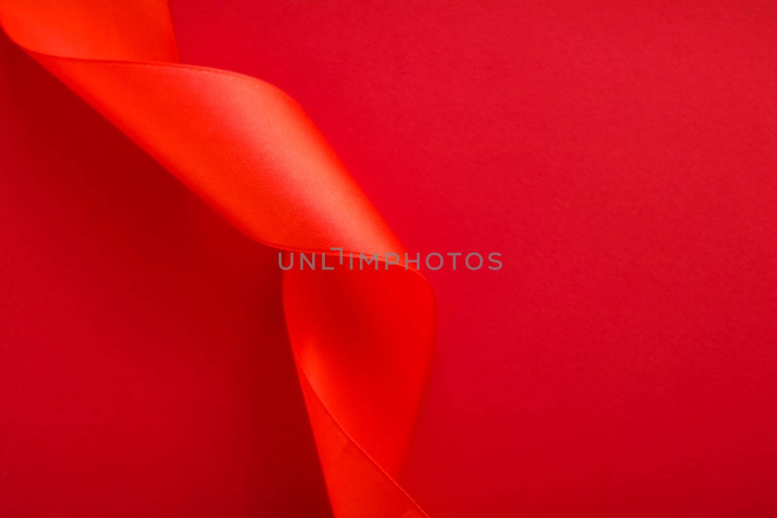 Branding, holidays and luxe brands concept - Abstract curly silk ribbon on red background, exclusive luxury brand design for holiday sale product promotion and glamour art invitation card backdrop