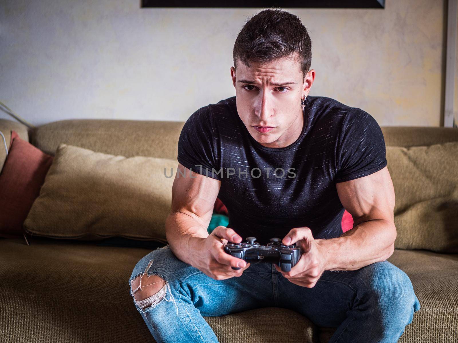 Good looking young man holding joystick, gamepad or joypadplaying video game