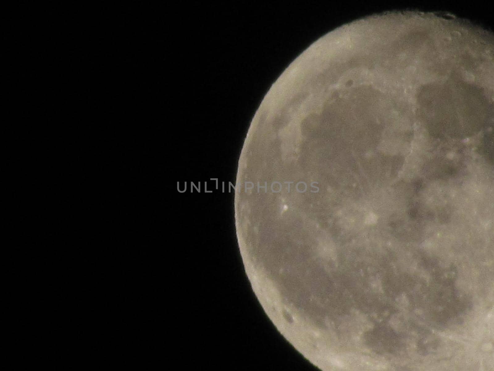 The Moon close-up on a black night sky shot through a telephoto camera. by Photochowk