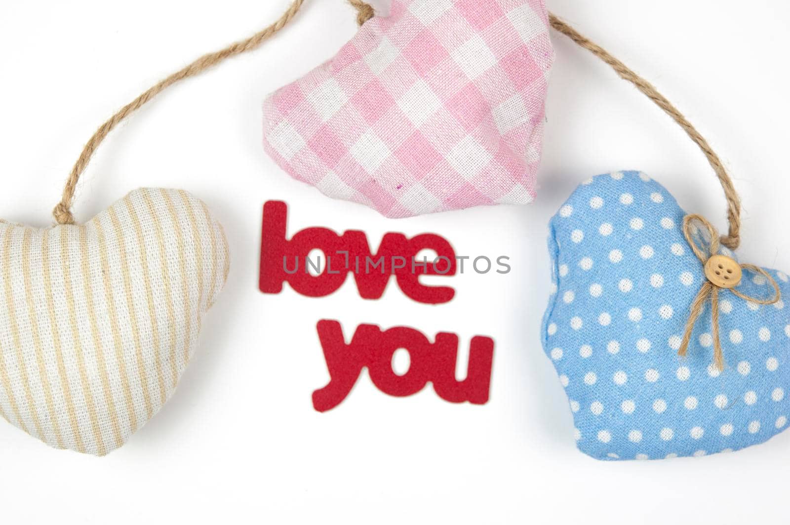 Valentine's day card. Top view cute composition with handmade fabric hearts on white paper background. Happy birthday or anniversary congratulation. Romantic message template with copy space.