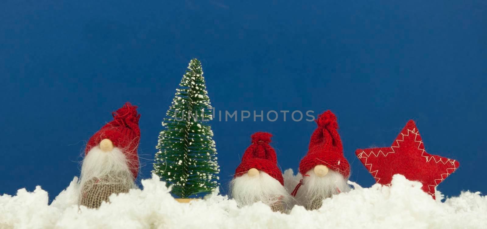 Christmas card made of fir tree with viburnum berries and toy gnome on the wooden rustic background.Christmas background.Copy space for text