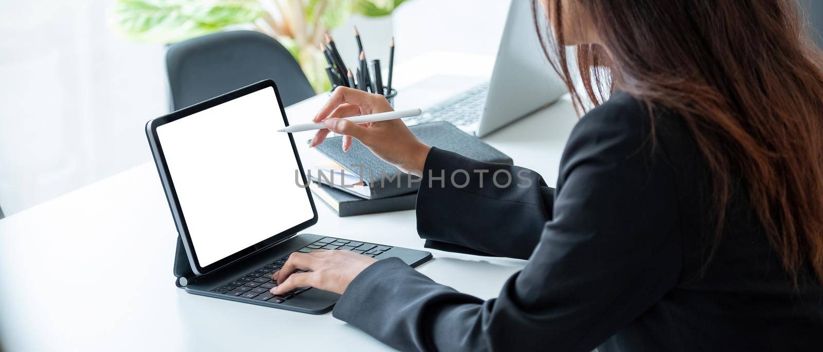 Cropped shot of a business woman sitting at modern office room and using blank screen digital tablet computer with pen stylus.