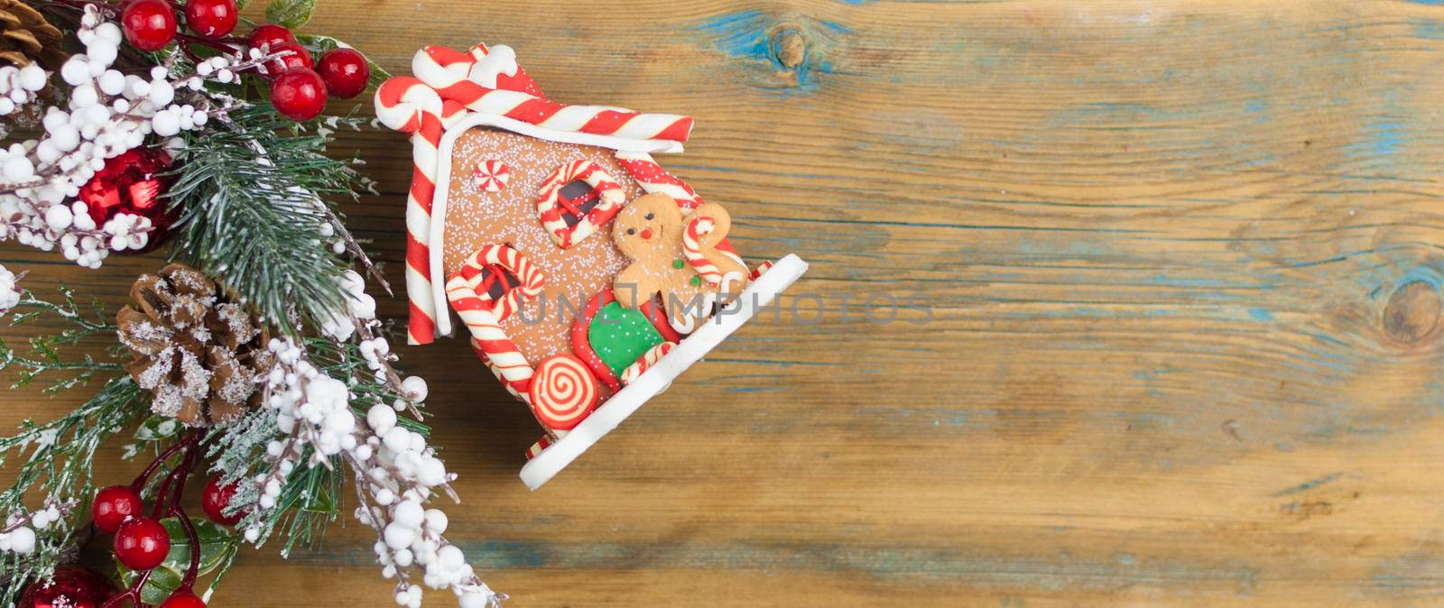 Gingerbread house with Christmas decorations on wooden background with space for your text by inxti