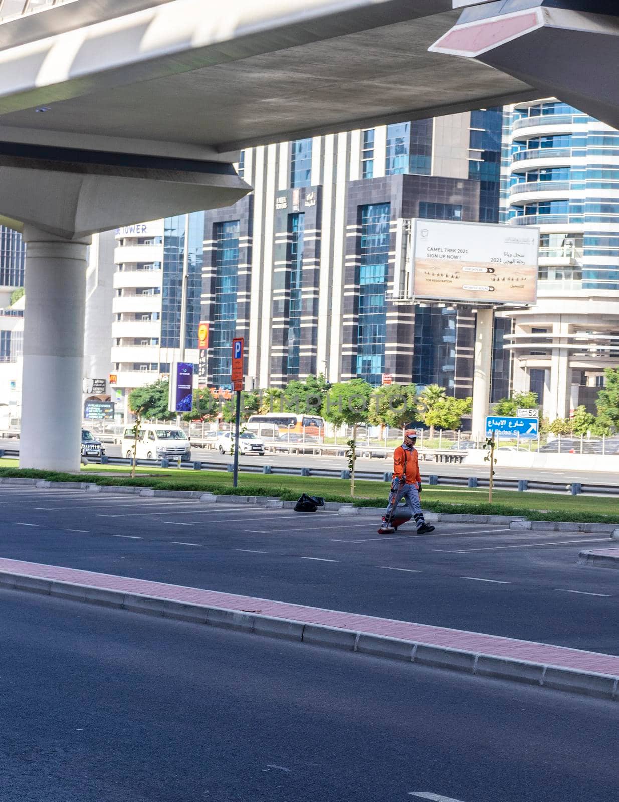 Dubai, UAE - 10.04.2021 Cleaner cleaning parking lots at Sheikh Zayed road