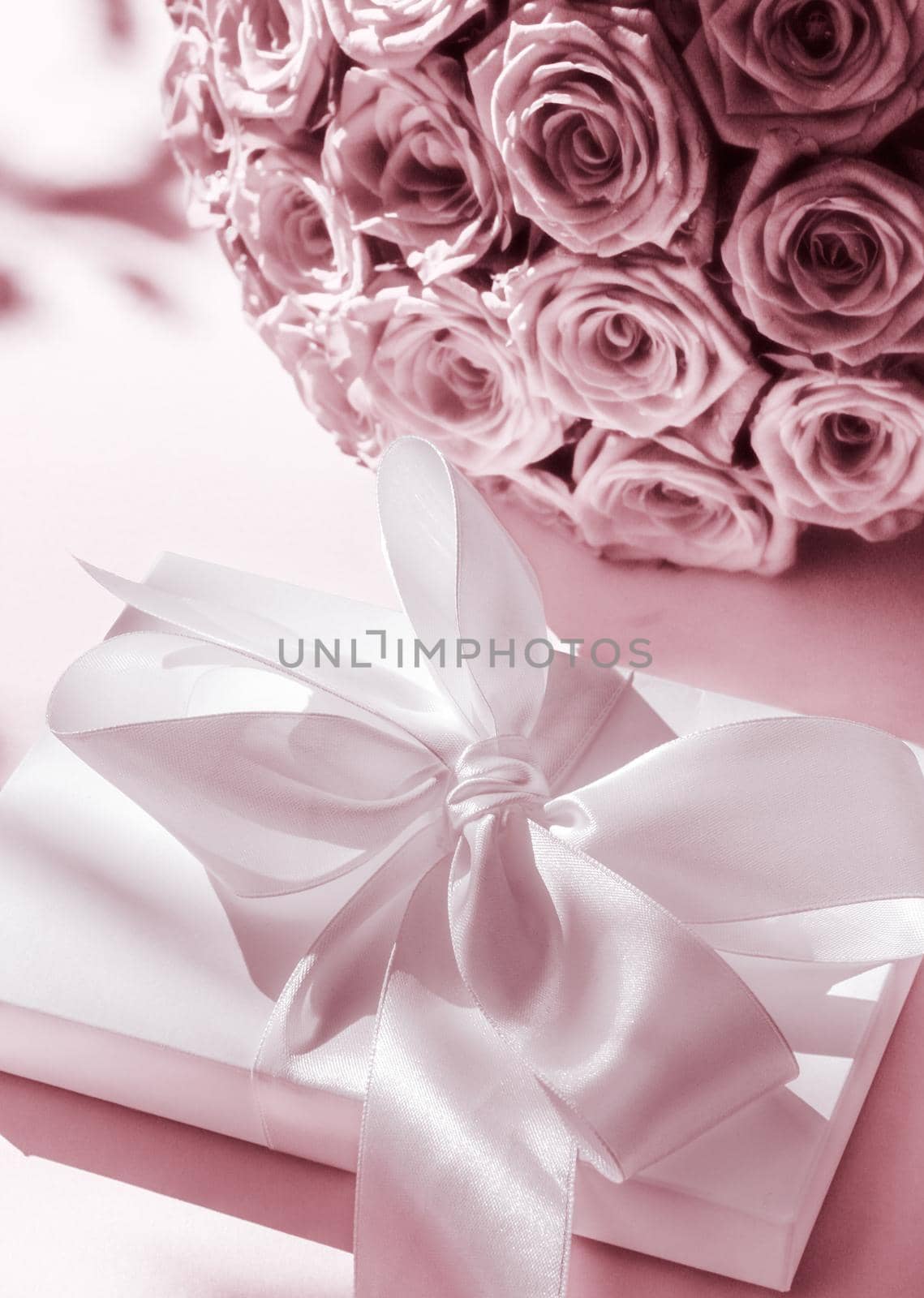 Happy holidays, luxe shopping and love gifts concept - Luxury holiday silk gift box and bouquet of roses on blush pink background, romantic surprise and flowers as birthday or Valentines Day present