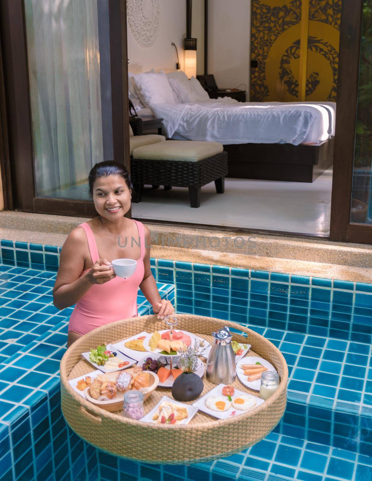 women having breakfast in swimming pool , Asian women having floating breakfast by fokkebok