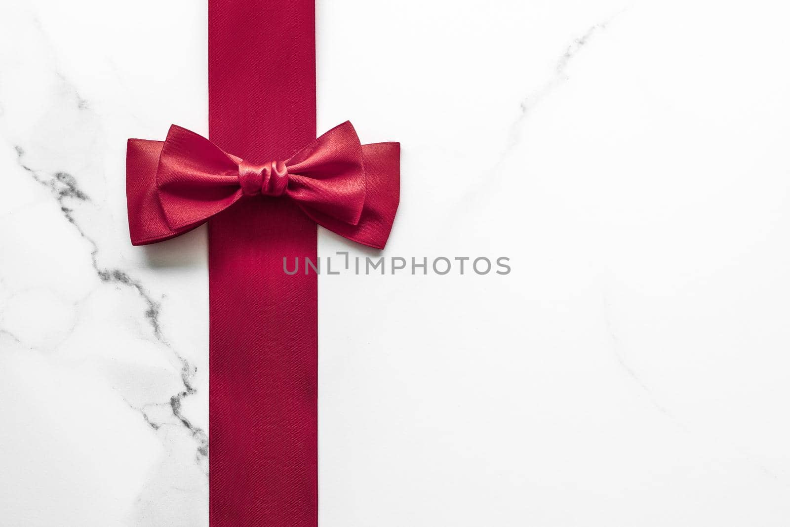 Holiday gift, decoration and sale promotion concept - Bordeaux silk ribbon on marble background, flatlay