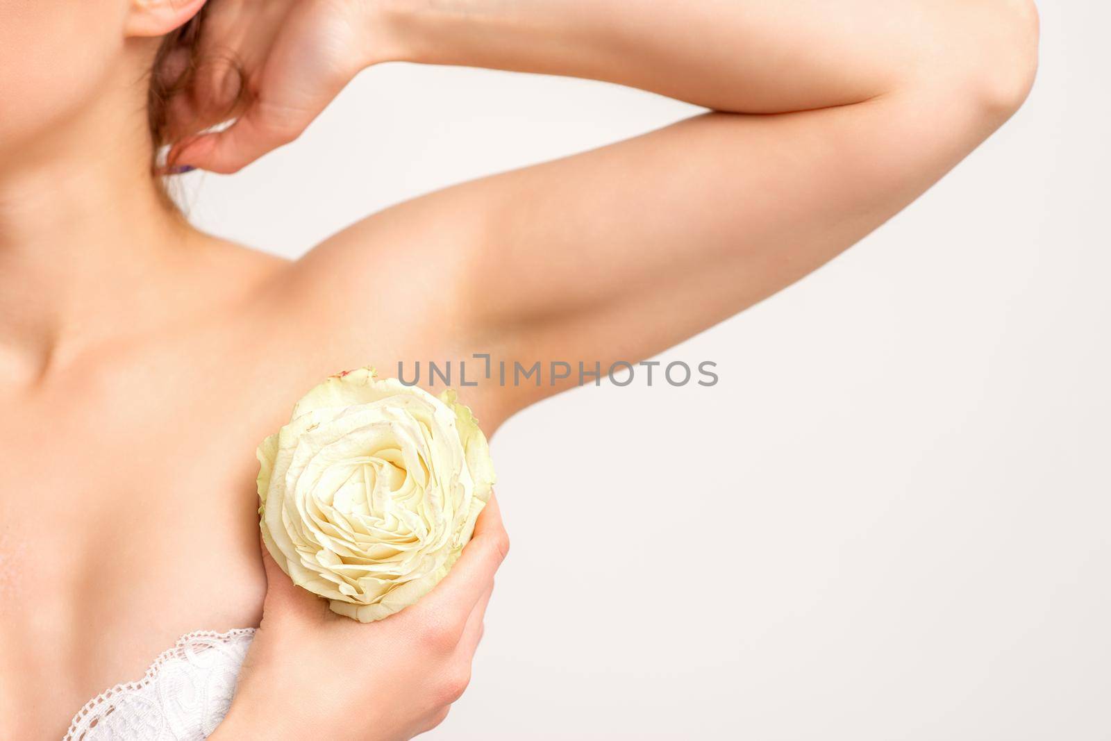 Close up of female armpit with white rose flower isolated on white background
