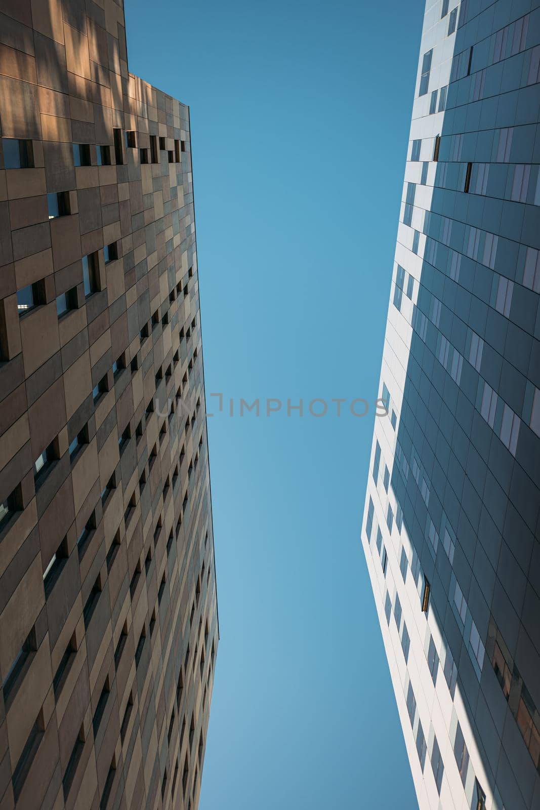 Office and residential skyscrapers on clear blue sky. Commercial real estate and modern business city district. by apavlin
