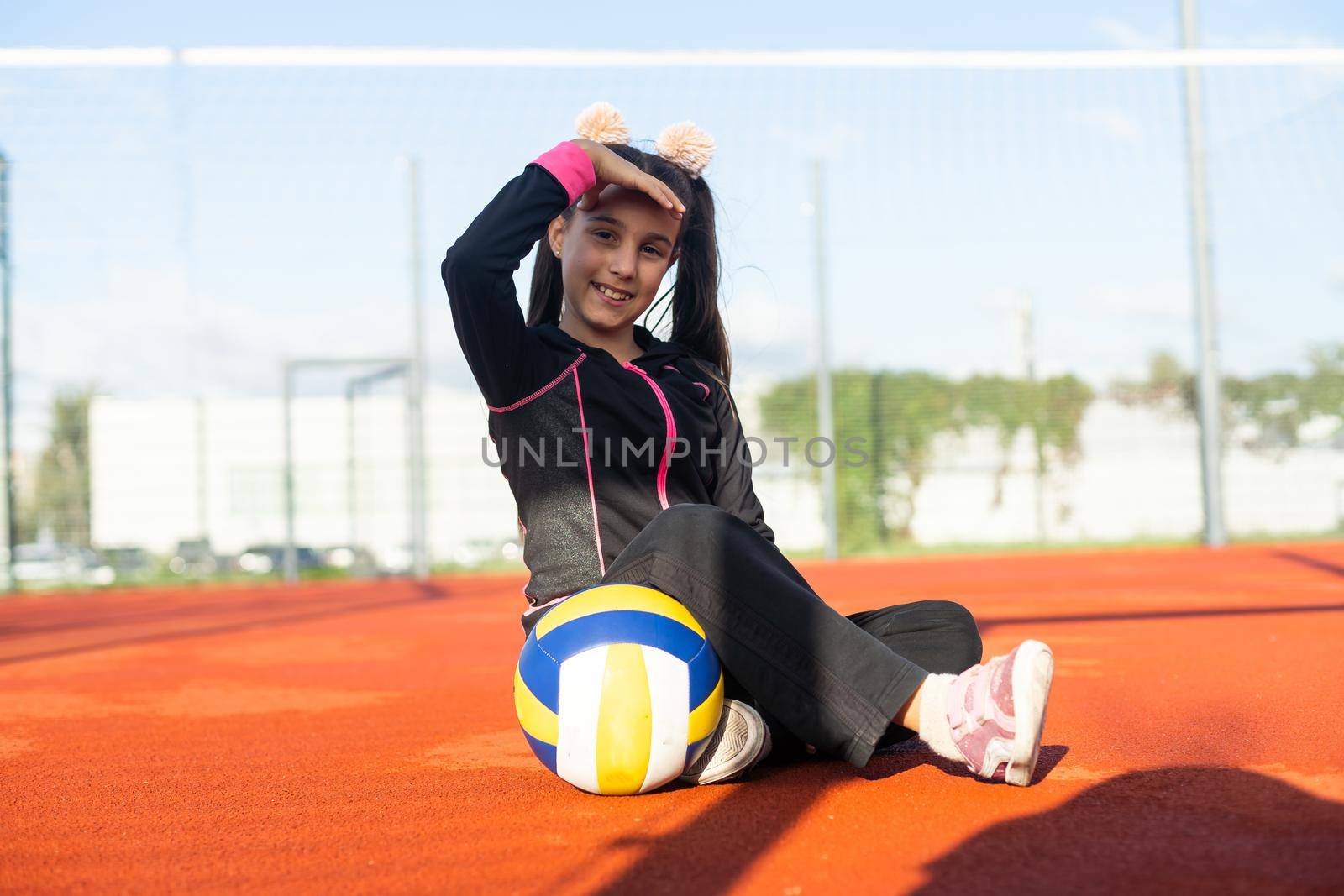 Cute girl playing ball. Girl with a blue-yellow volleyball.