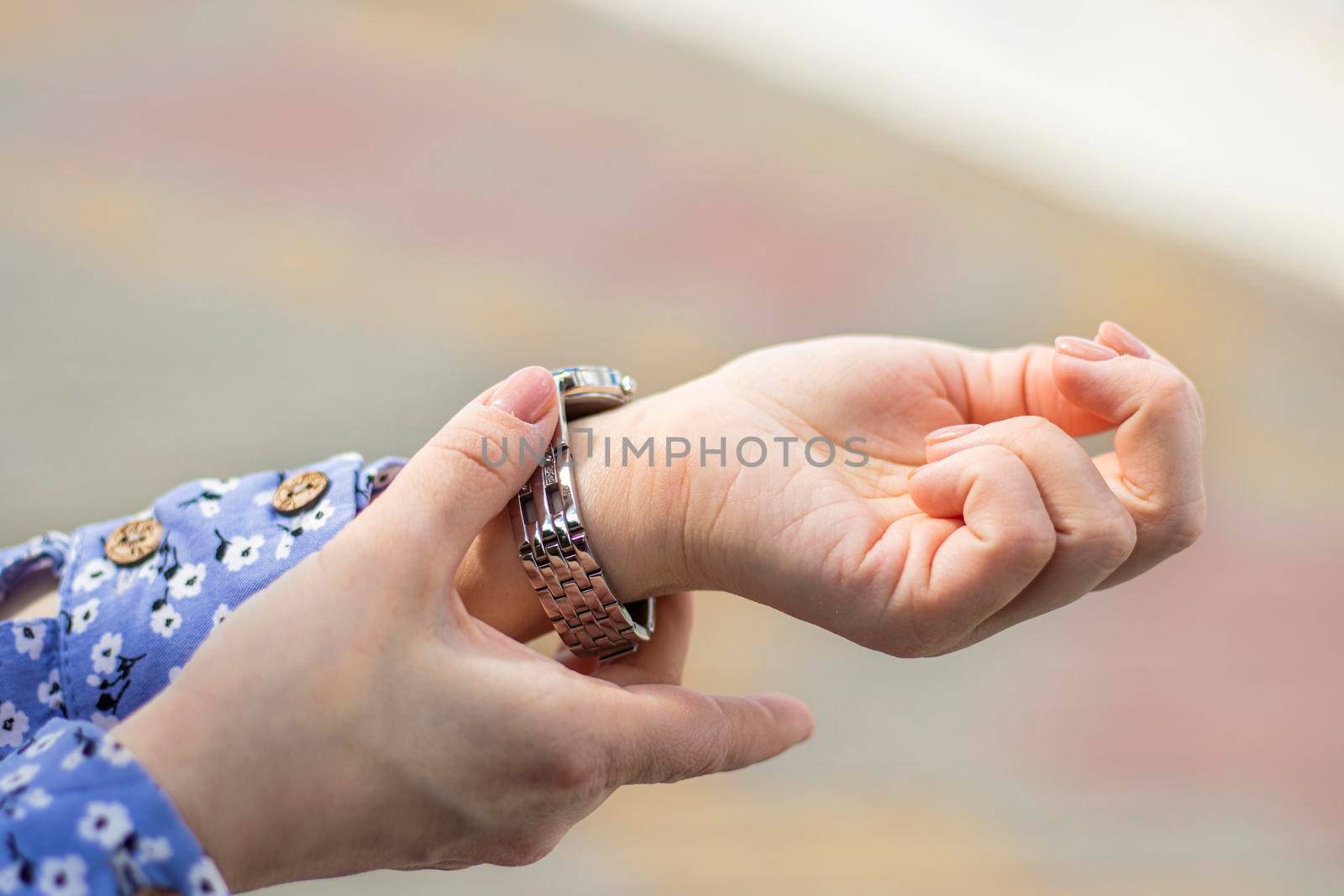 selective focus. female hands. The female fastens her watch. by Suietska