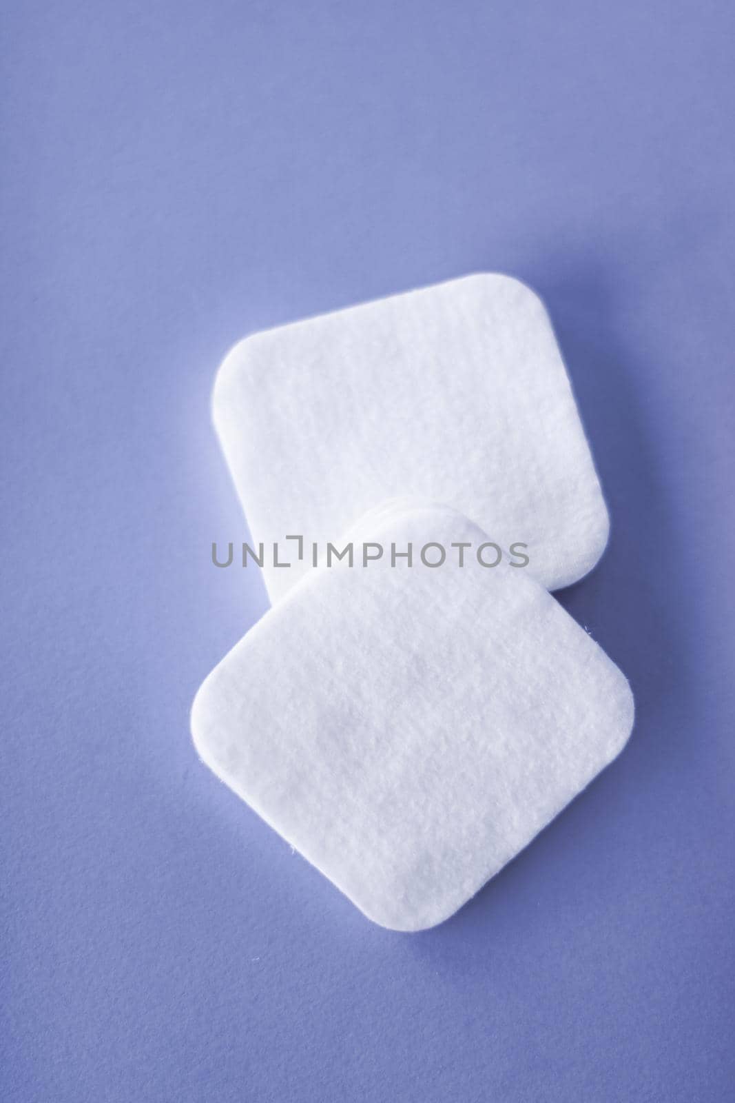 Cosmetology, cleanliness and branding concept - Organic cotton pads on purple background, cosmetics and make-up remover, hygiene and skincare beauty brand product for healthcare and medical design