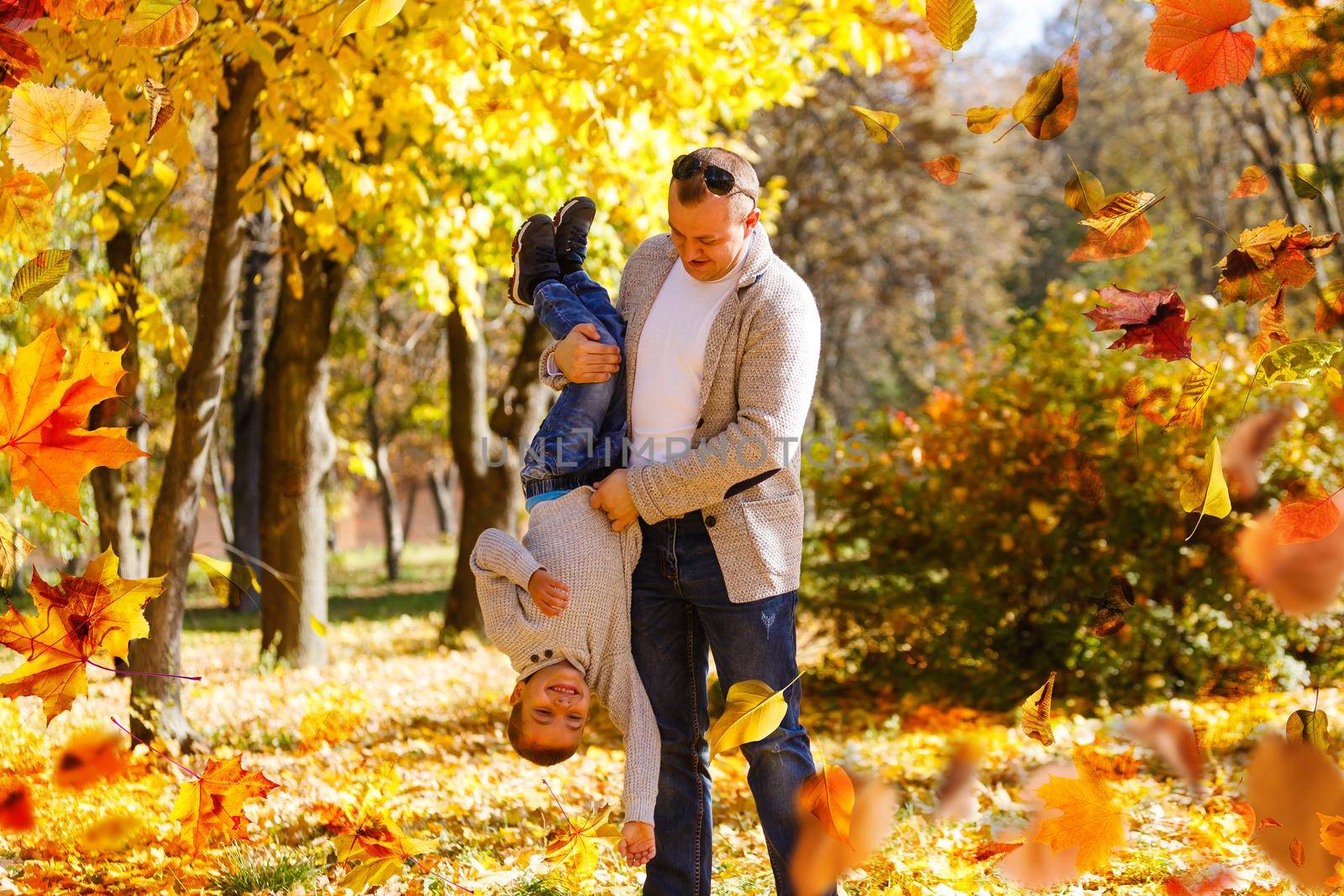 happy family father and child girl daughter playing and laughing in autumn park . High quality photo