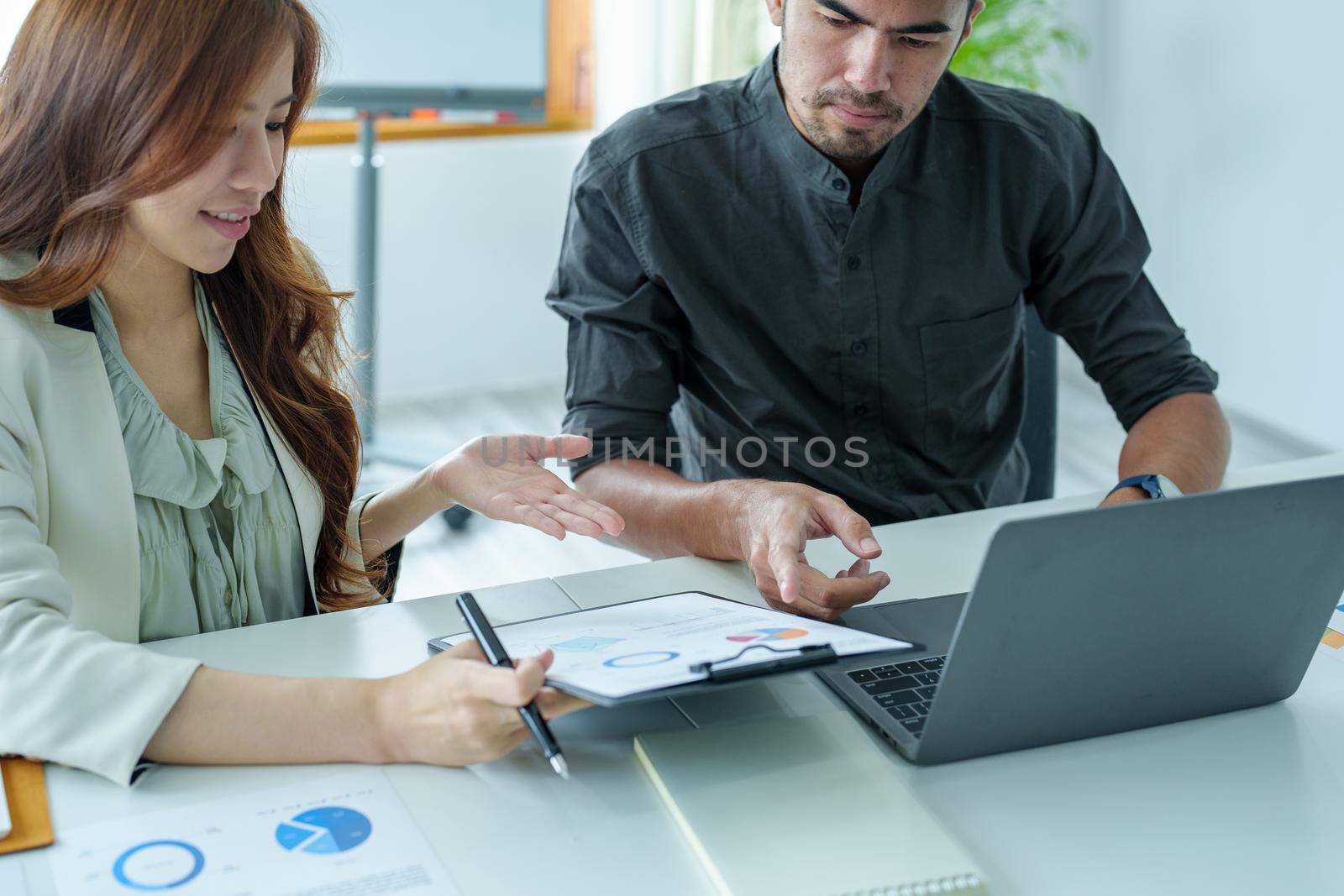 A portrait of a female marketer and a male salesperson discussing how to increase sales by investing in new products to expand marketing using documents and computers in working, new idea product.